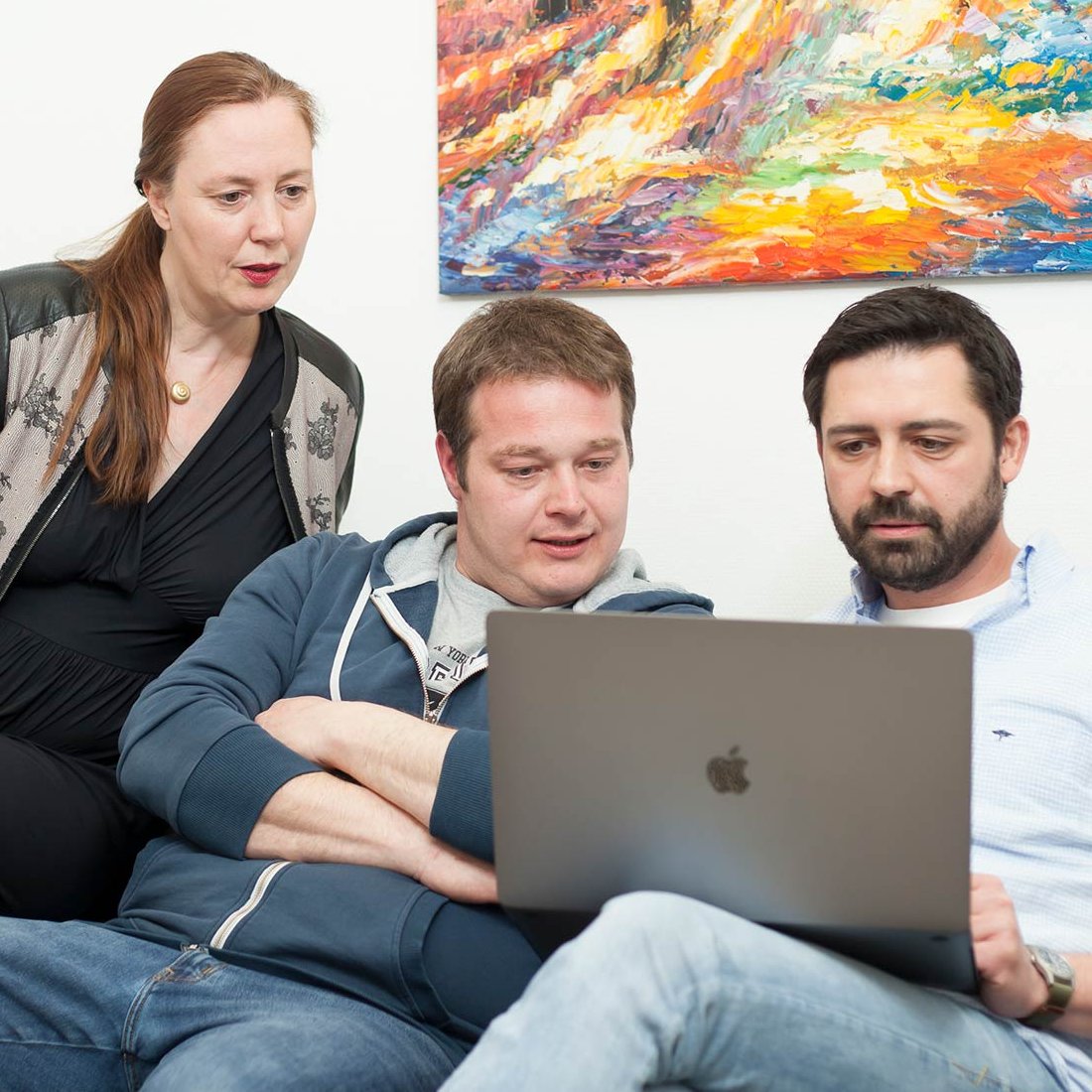 Mitarbeitende mindmelt auf einer Couch mit Blick in ein Laptop